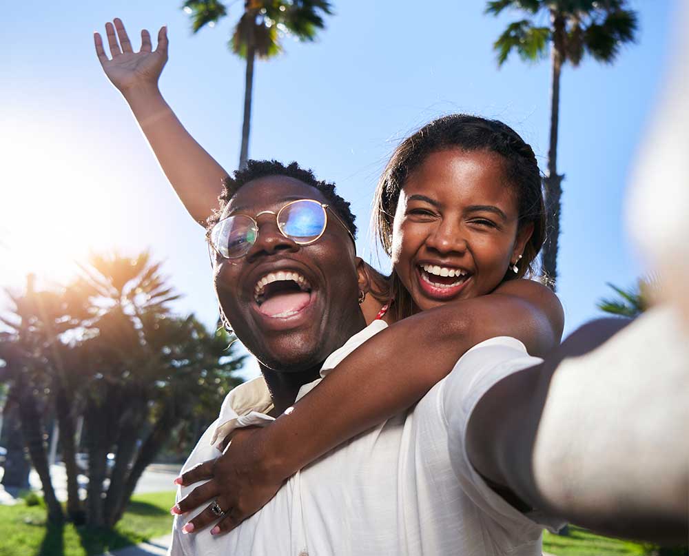 travelers taking a selfie with palm trees