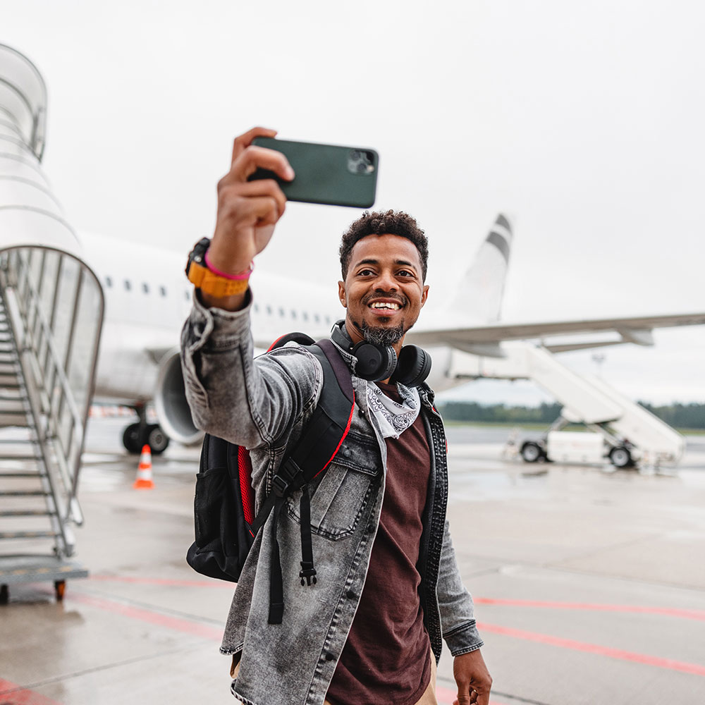 man taking selfie coming off the airplane